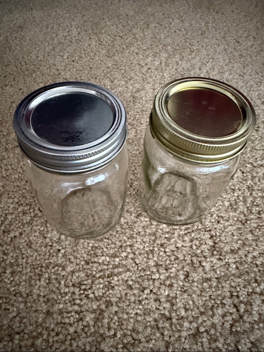 Two Clear Glass Mason Jars with Silver and Gold Lids